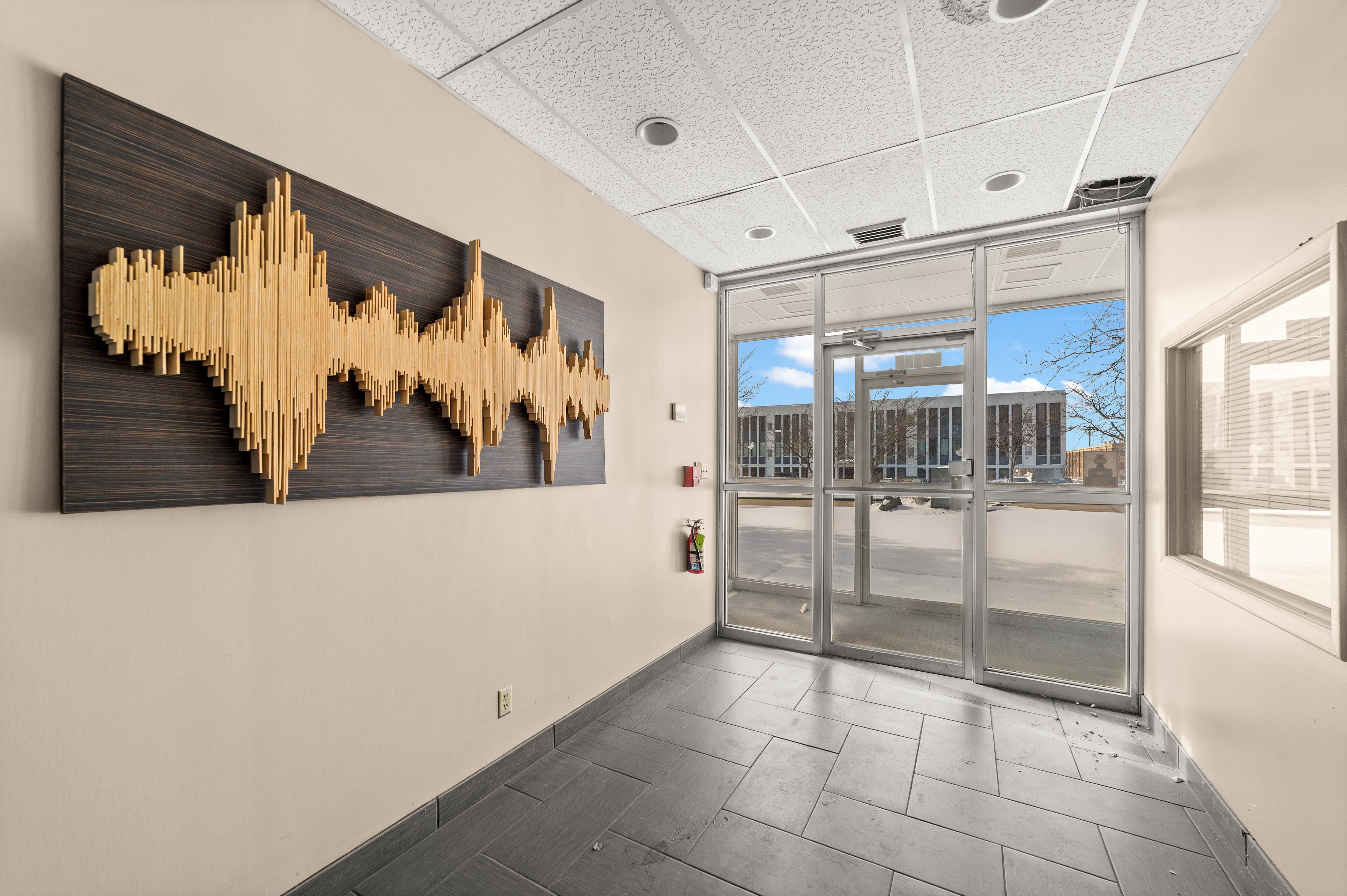 Commercial entryway with wooden soundwave art