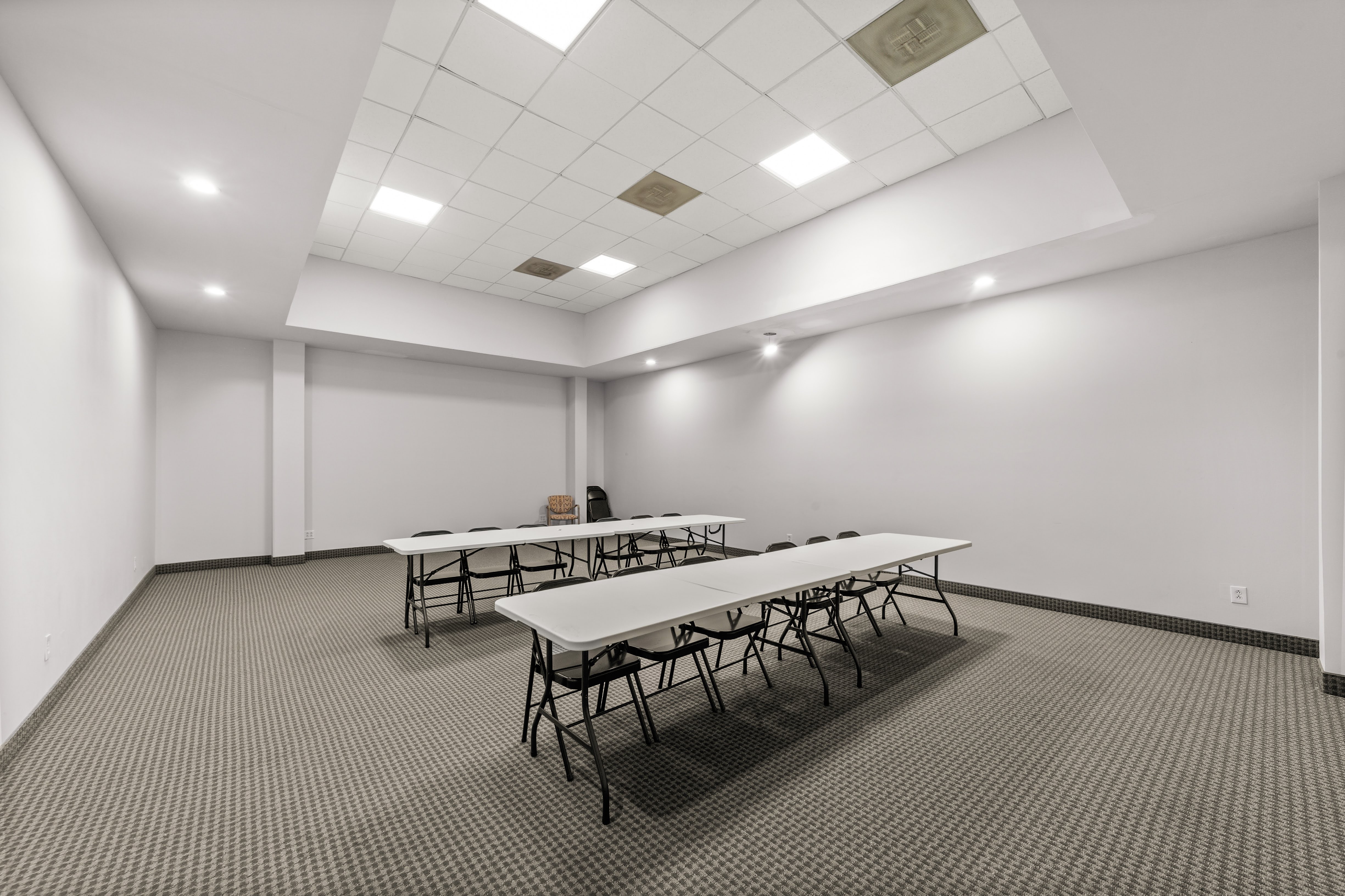Empty conference room with rows of white folding tables