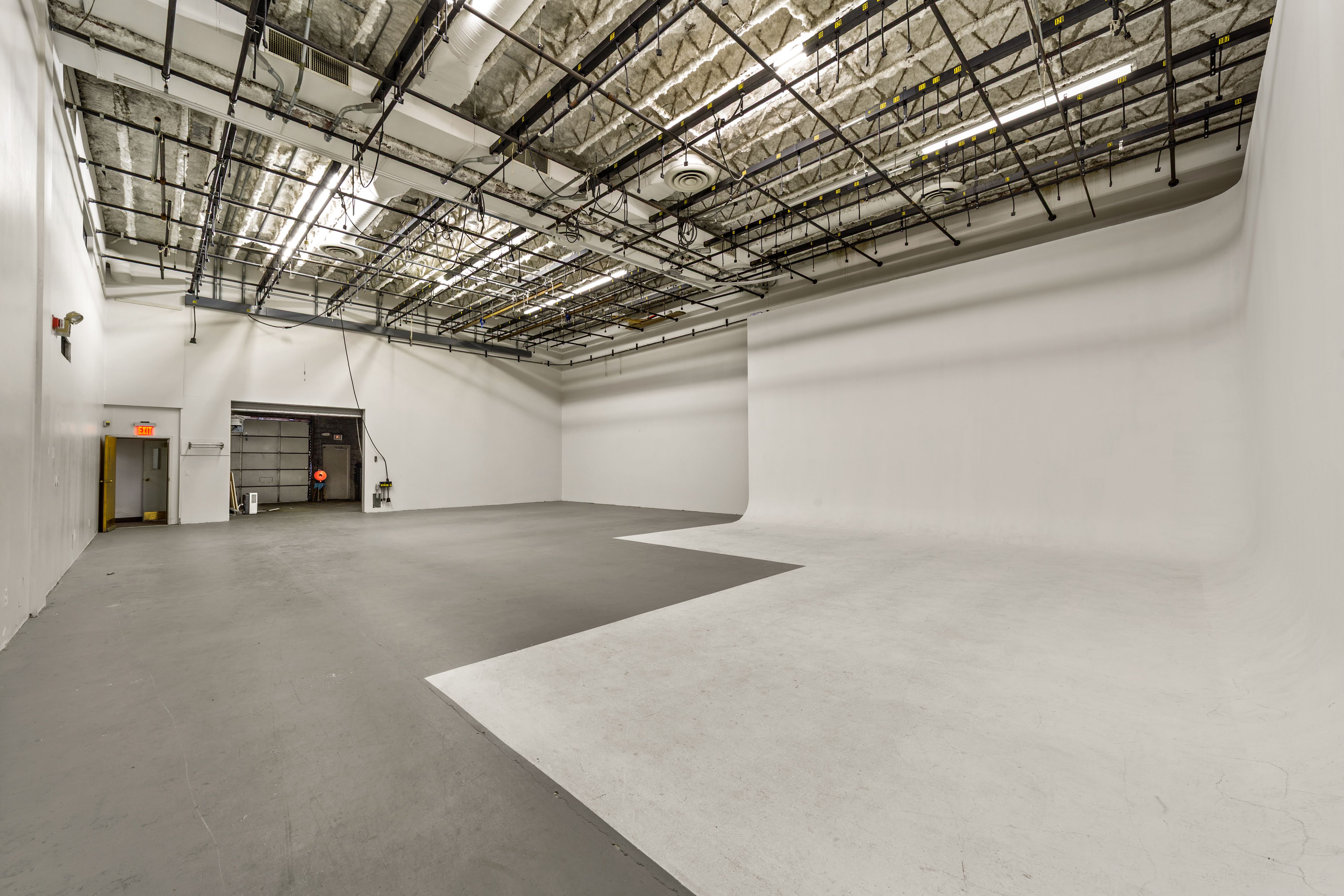 Empty industrial photo studio with seamless white backdrop