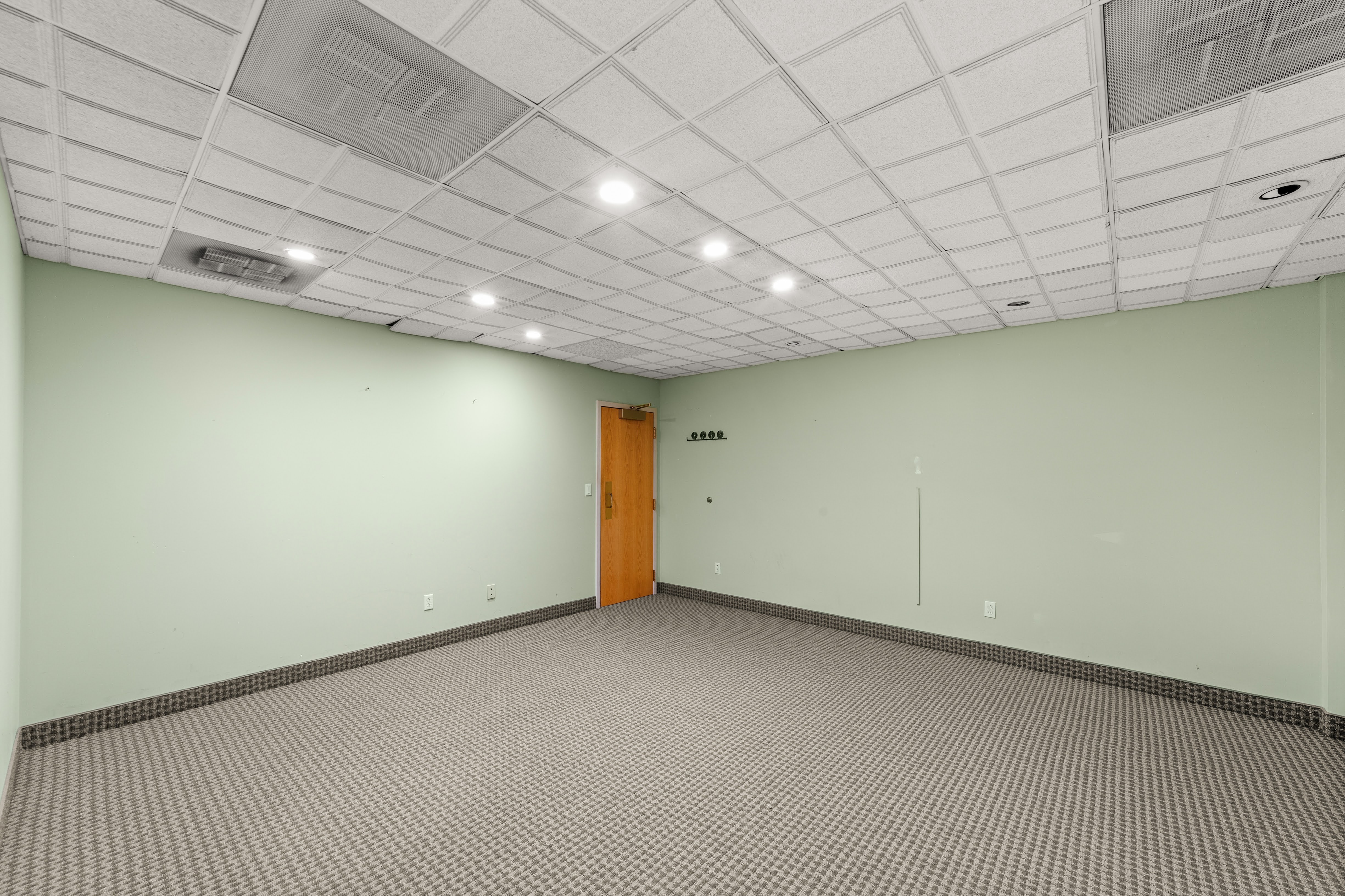 Empty office room with coat rack and wooden door