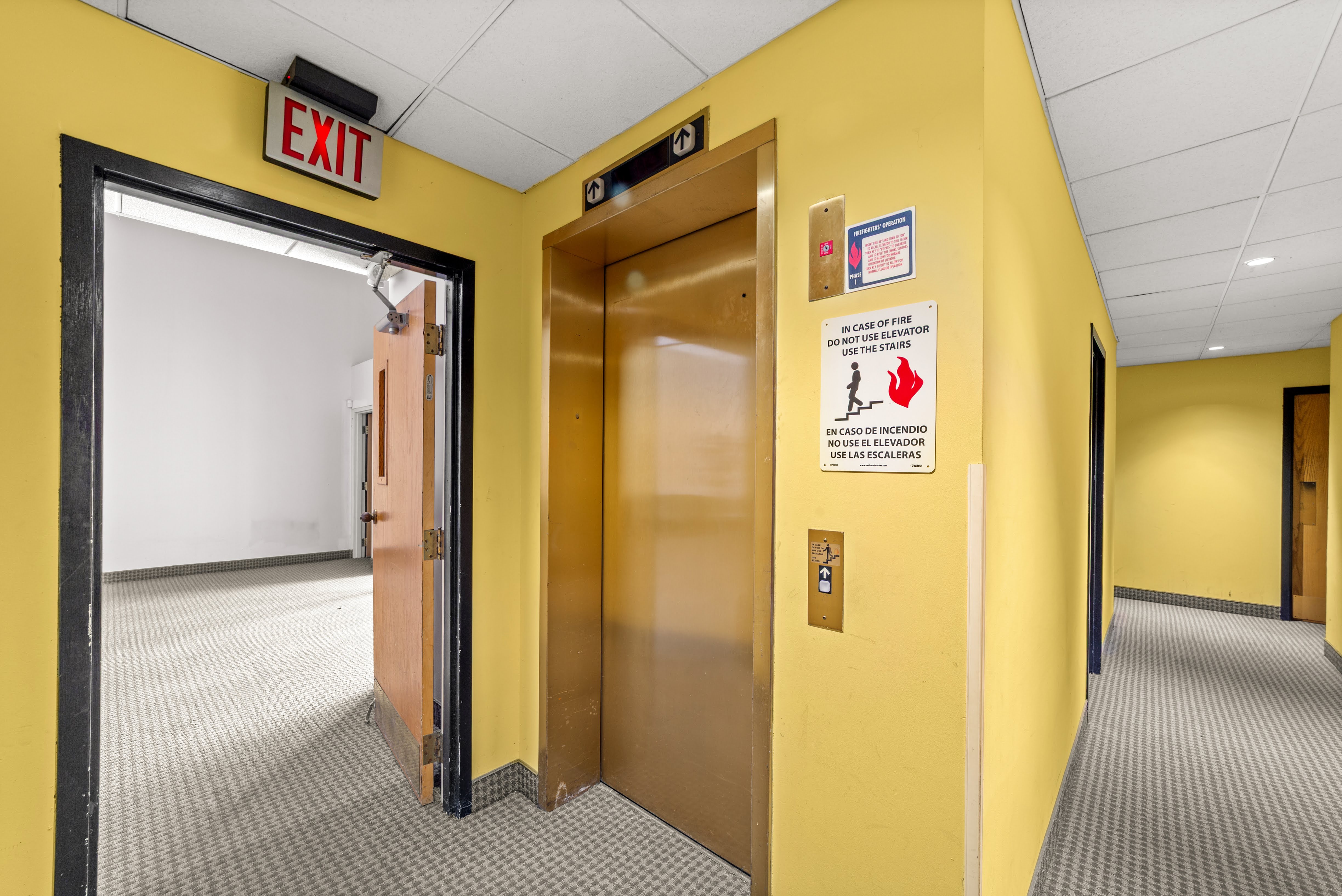 Hallway with brass elevator doors and EXIT sign