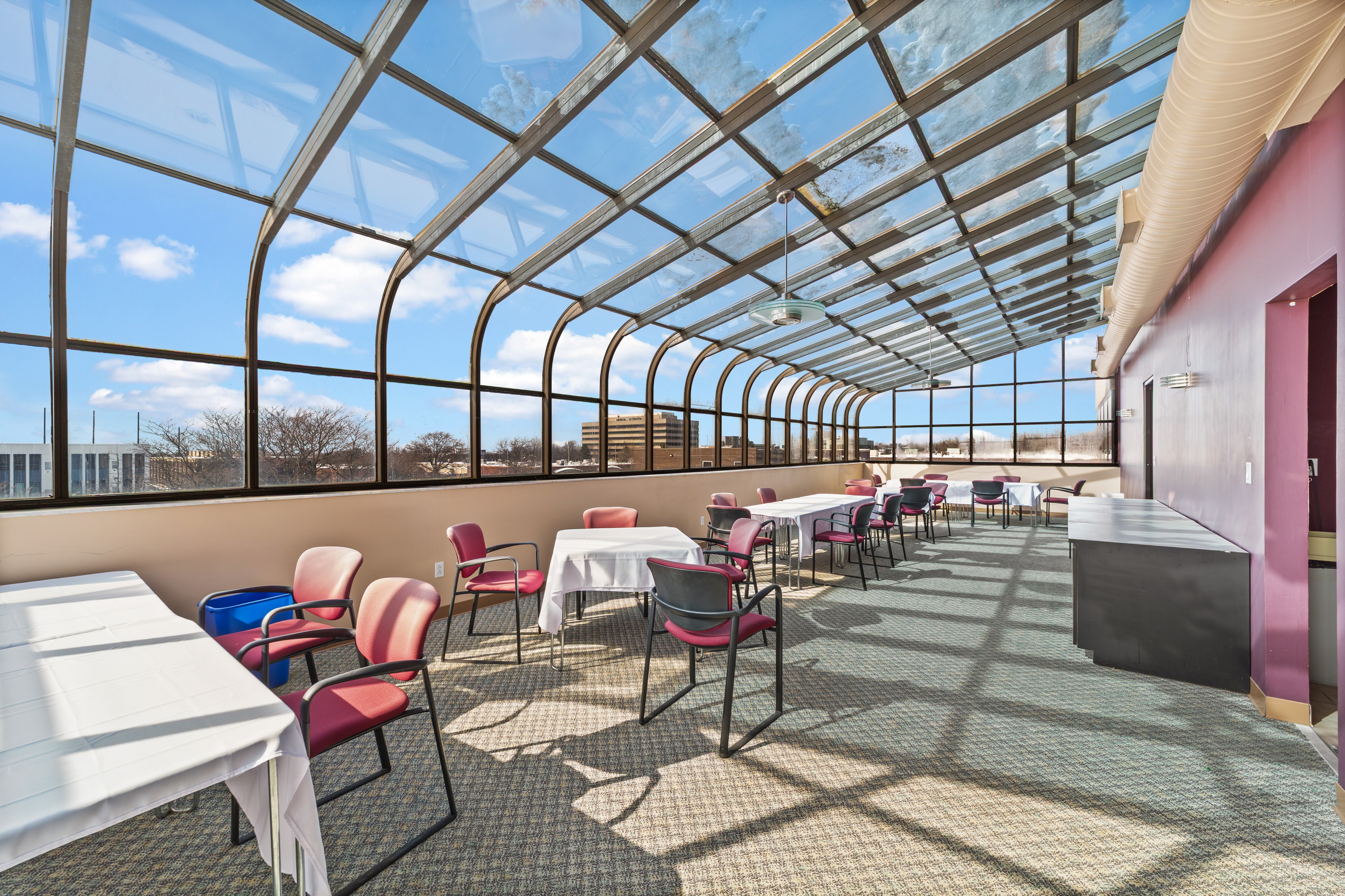 Bright glass-enclosed sunroom dining