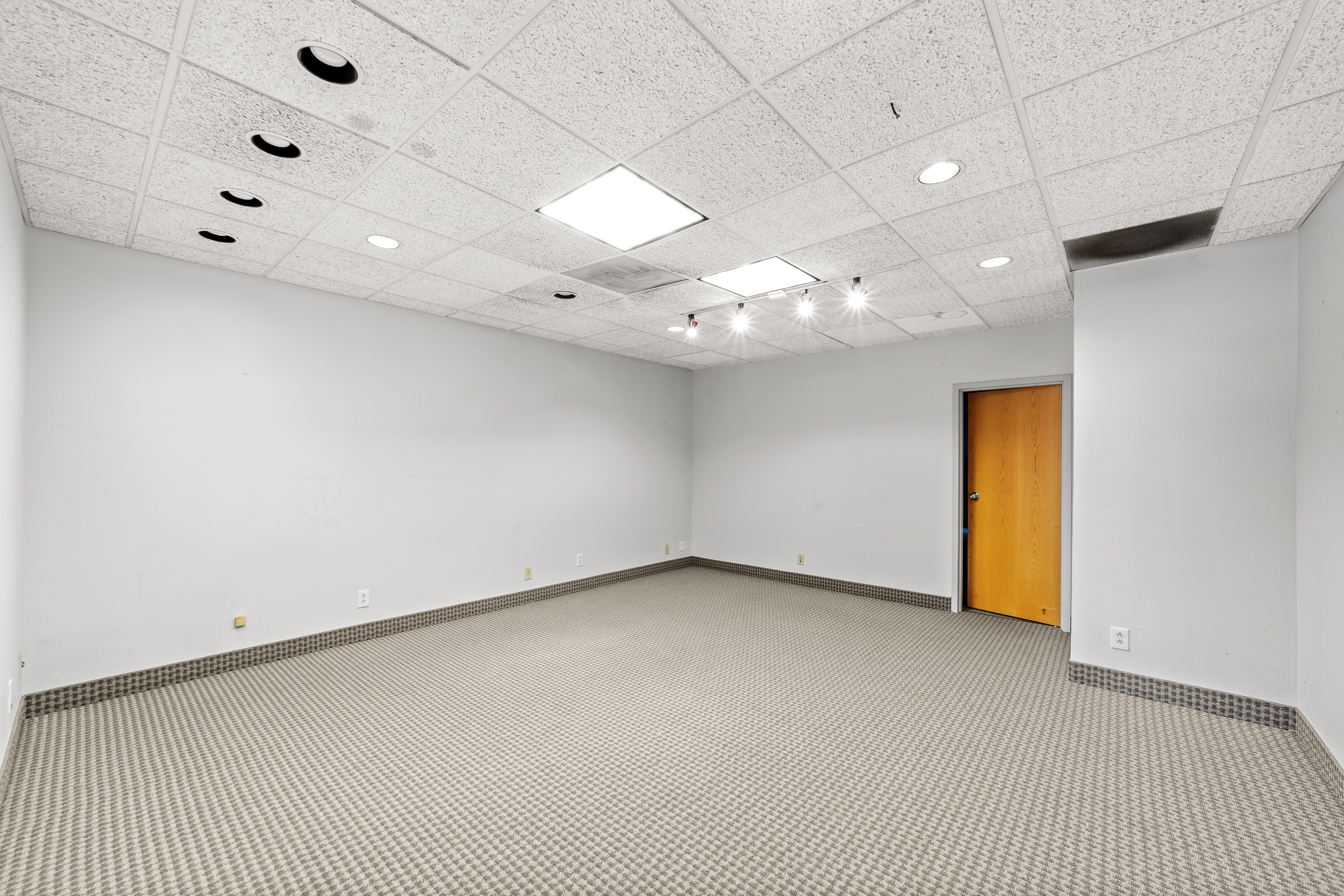 Brightly lit empty office space with wooden door