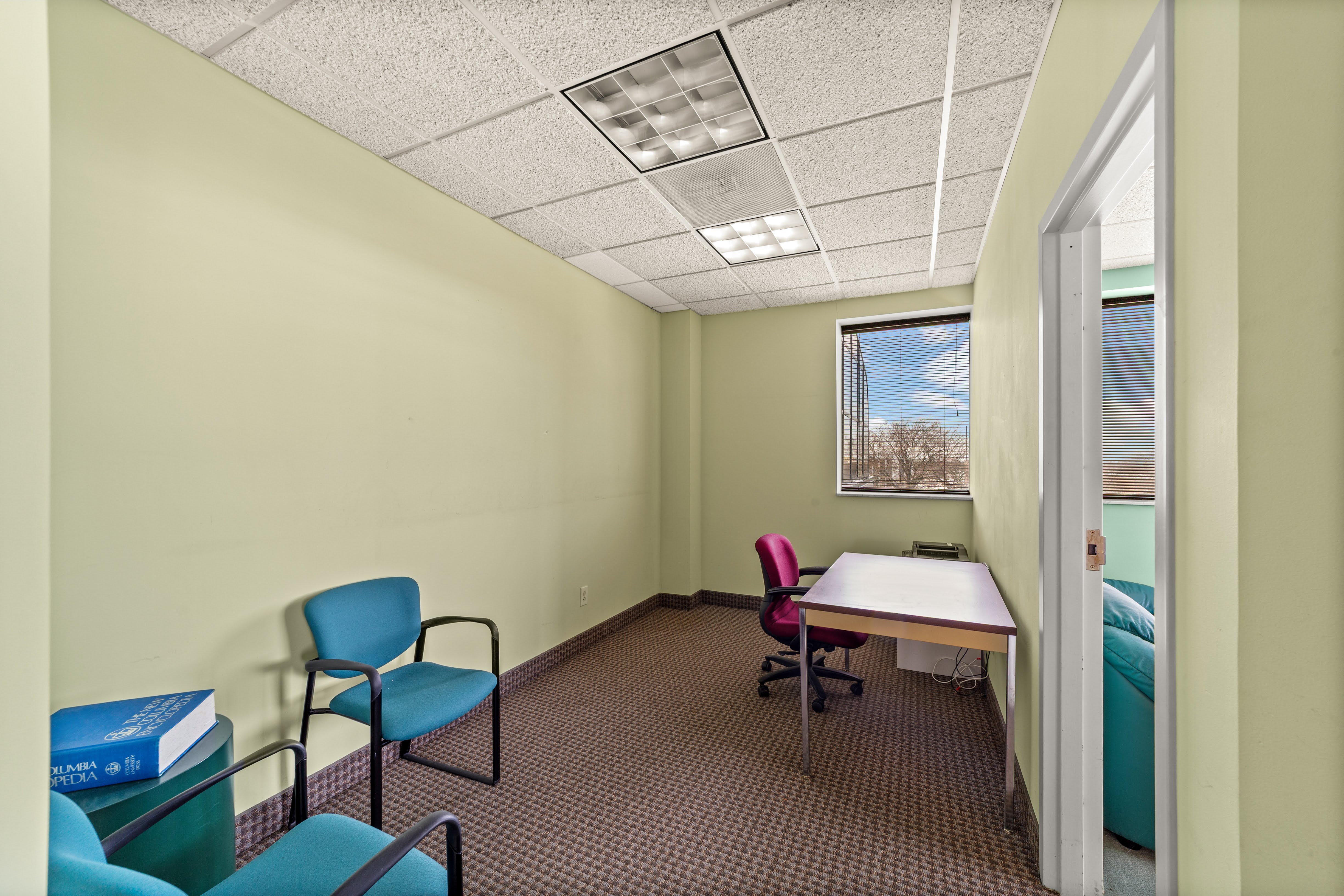 Light green office room with blue chairs