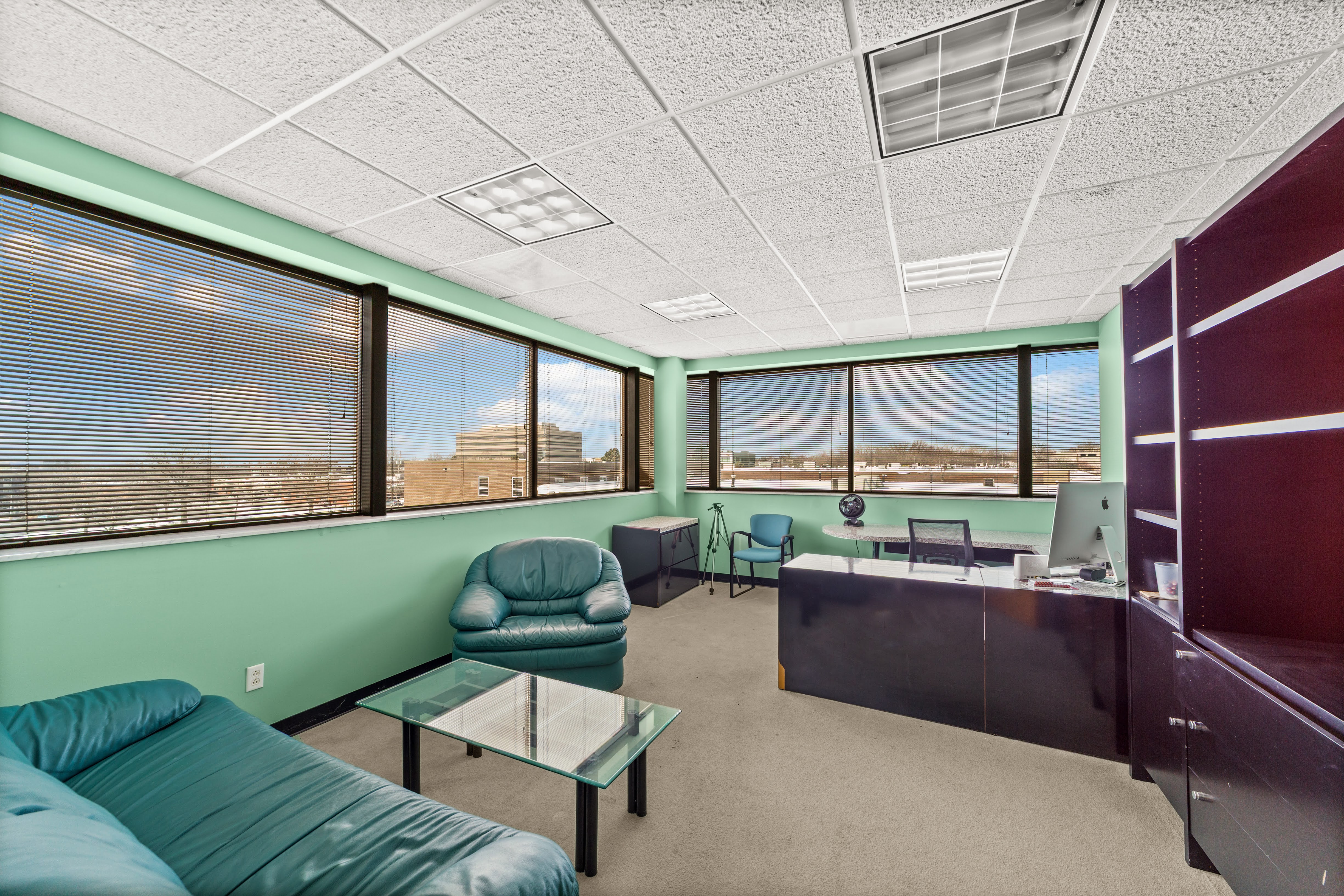 Vacant office with teal sofa and iMac