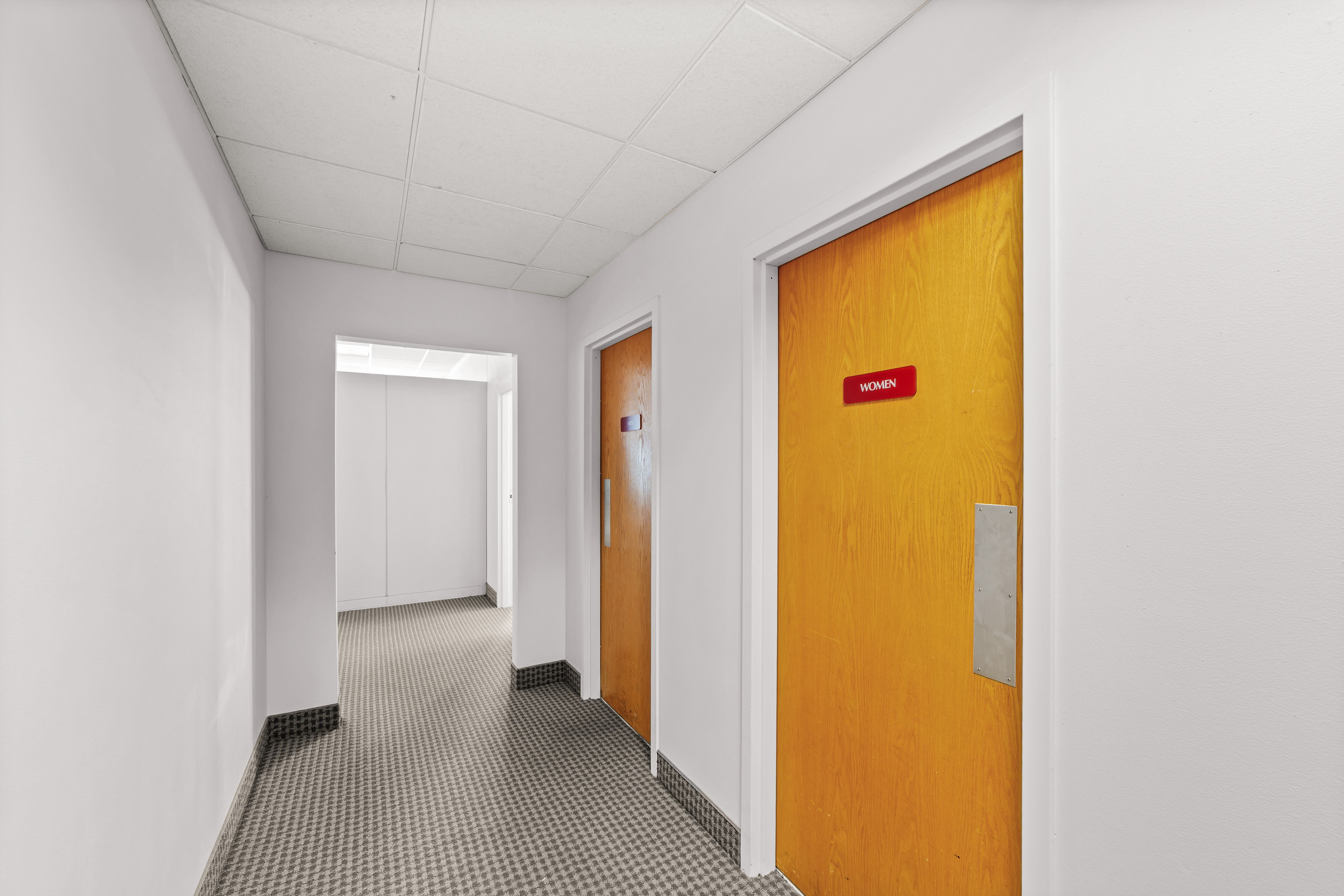 Carpeted hallway to men's and women's restrooms