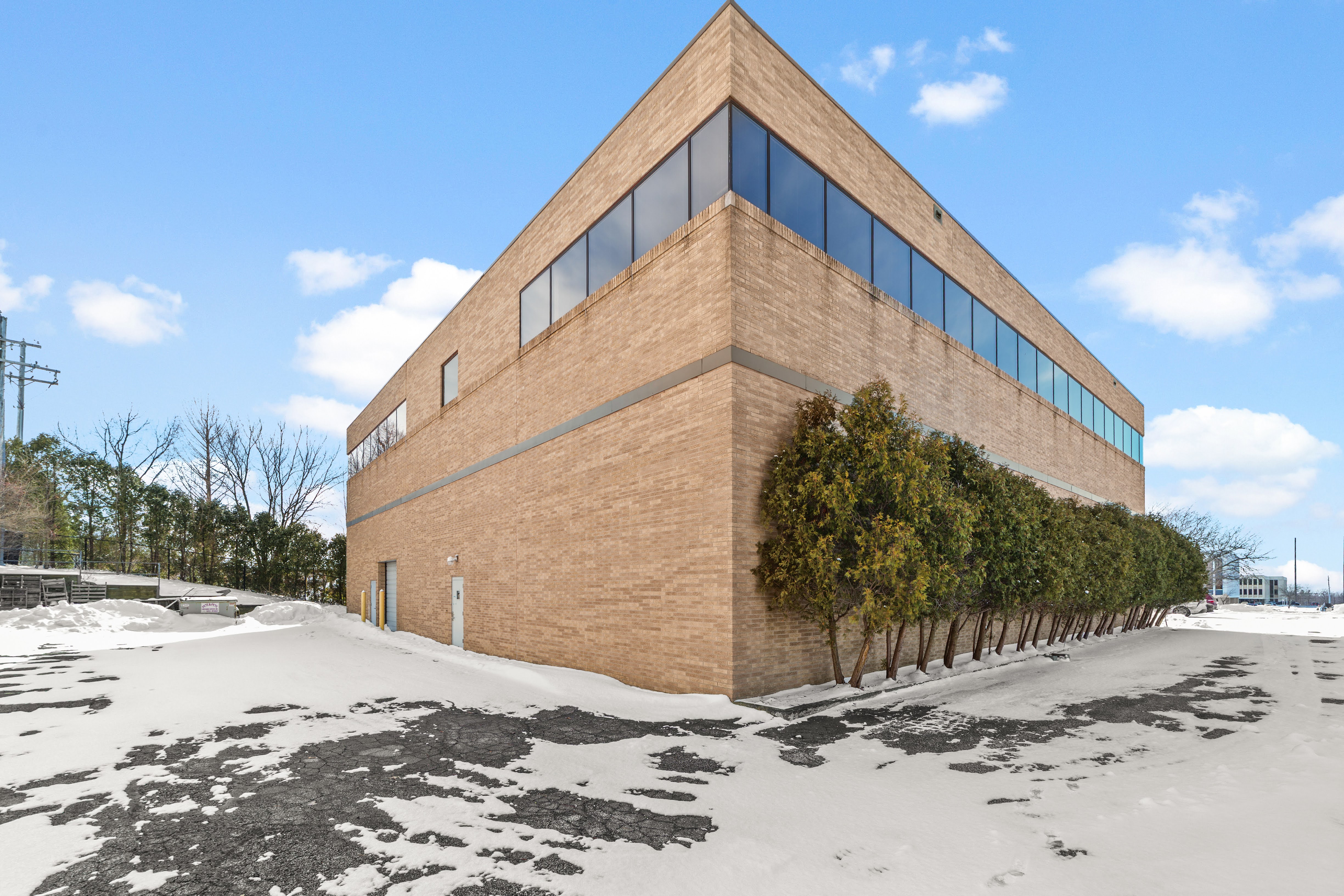 Tan brick commercial building with dark windows